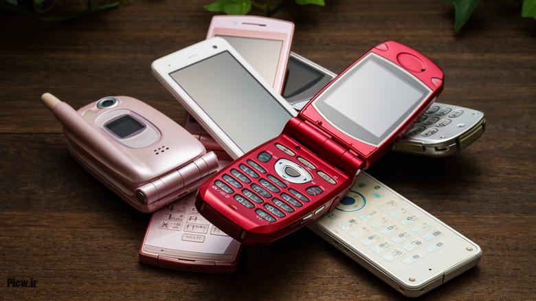 Old used cell phone on white background